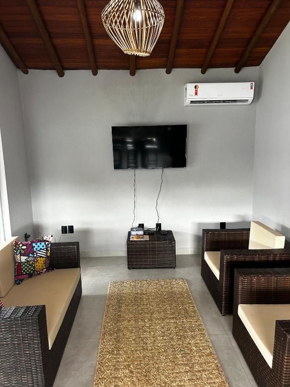 a living room with couches and a flat screen tv at Casa da Sil in Arraial d'Ajuda