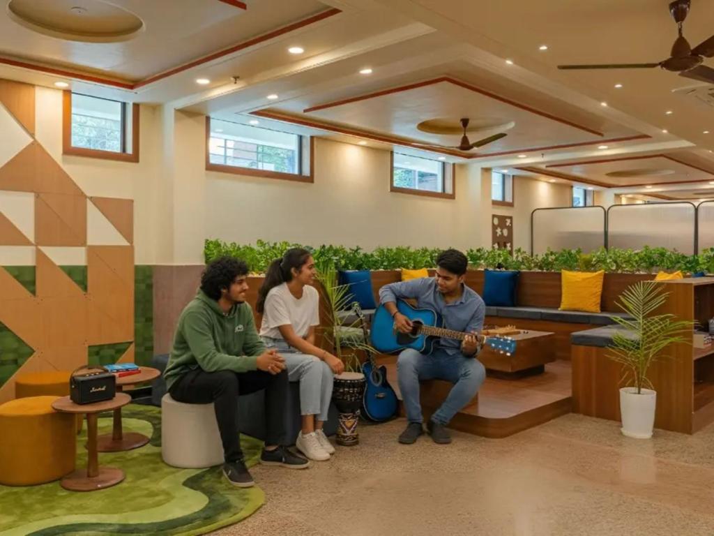 a group of people sitting in a lobby playing music at The Hosteller Agra, Tajganj in Agra