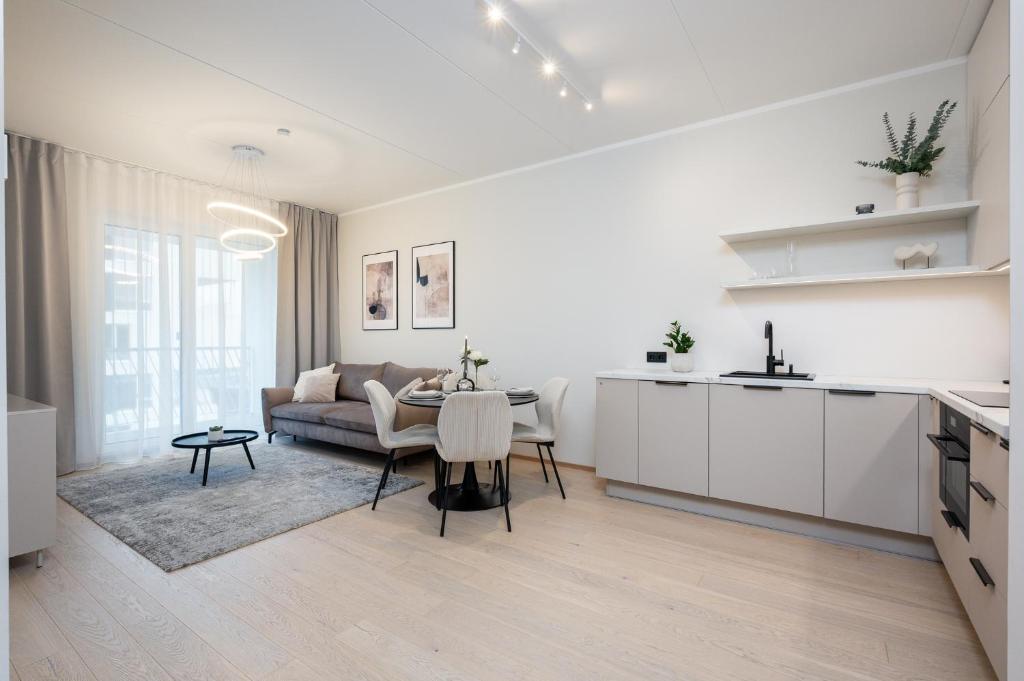 a kitchen and living room with a table and a couch at Siili Riverview Stay in Tartu
