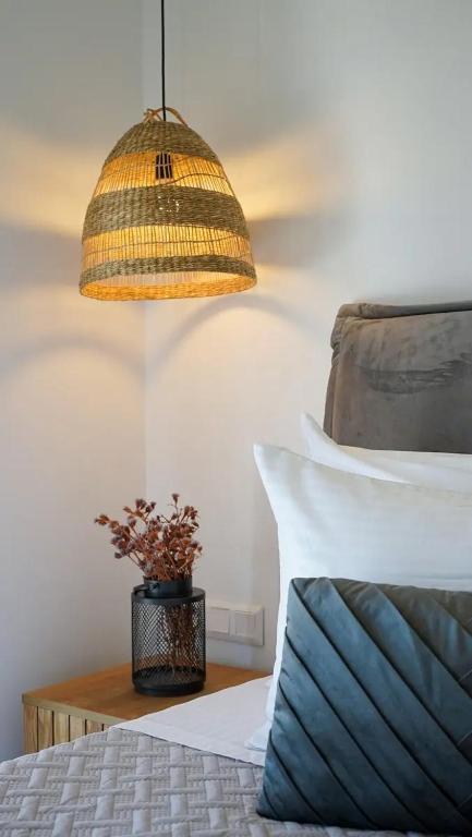 a bedroom with a bed with a lamp and a pillow at One Lemnos luxury Apartments in Lemnos