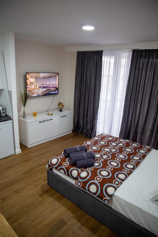 a bedroom with a large bed and a flat screen tv at Planet Residence - Harmony Lux & SPA in Niš