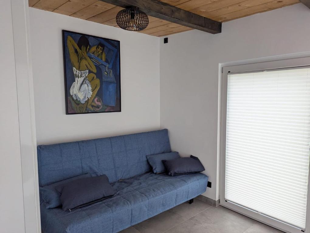 Wasserschloss Apt في Neukirchen: أريكة زرقاء في غرفة بها نافذة