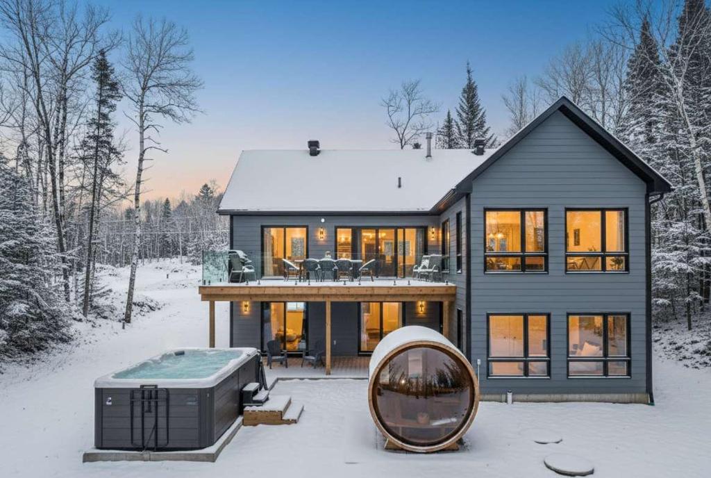 a large house with a tub in the snow at Brand New with Spa & Sauna - Le NaturO Spa in Saint Come