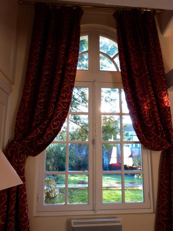 a window with red curtains in a room at L&#39;Orangerie White-Palacio in Versailles