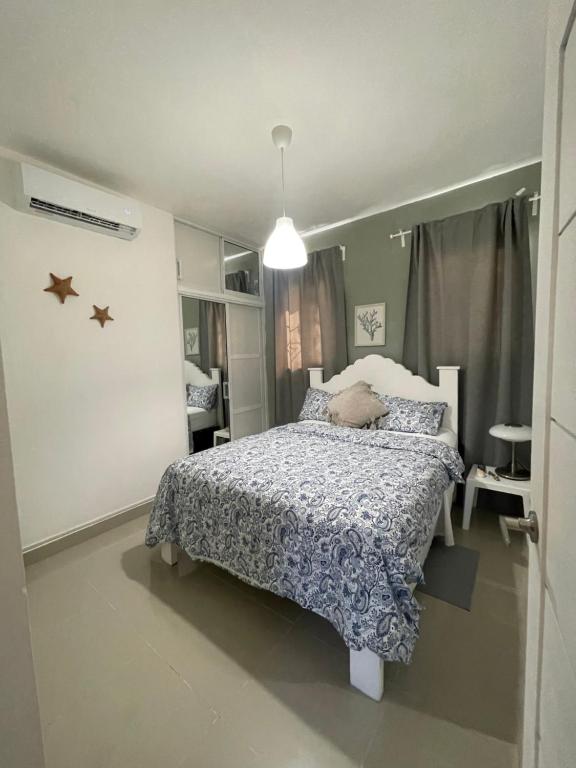 una camera da letto con un letto con un piumone blu e bianco di Cielo de hierro Apartamento especial con jacuzzi-special apartment with jacuzzi a La Romana