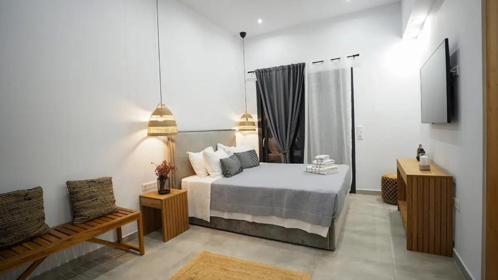 Un dormitorio con una cama, un sofá y un televisor. en One Lemnos Apartments, en Limnos