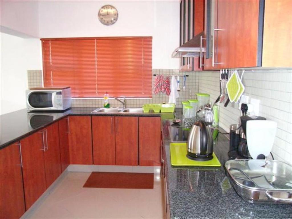 a kitchen with wooden cabinets and a counter top at Arabella No. 4 in Margate