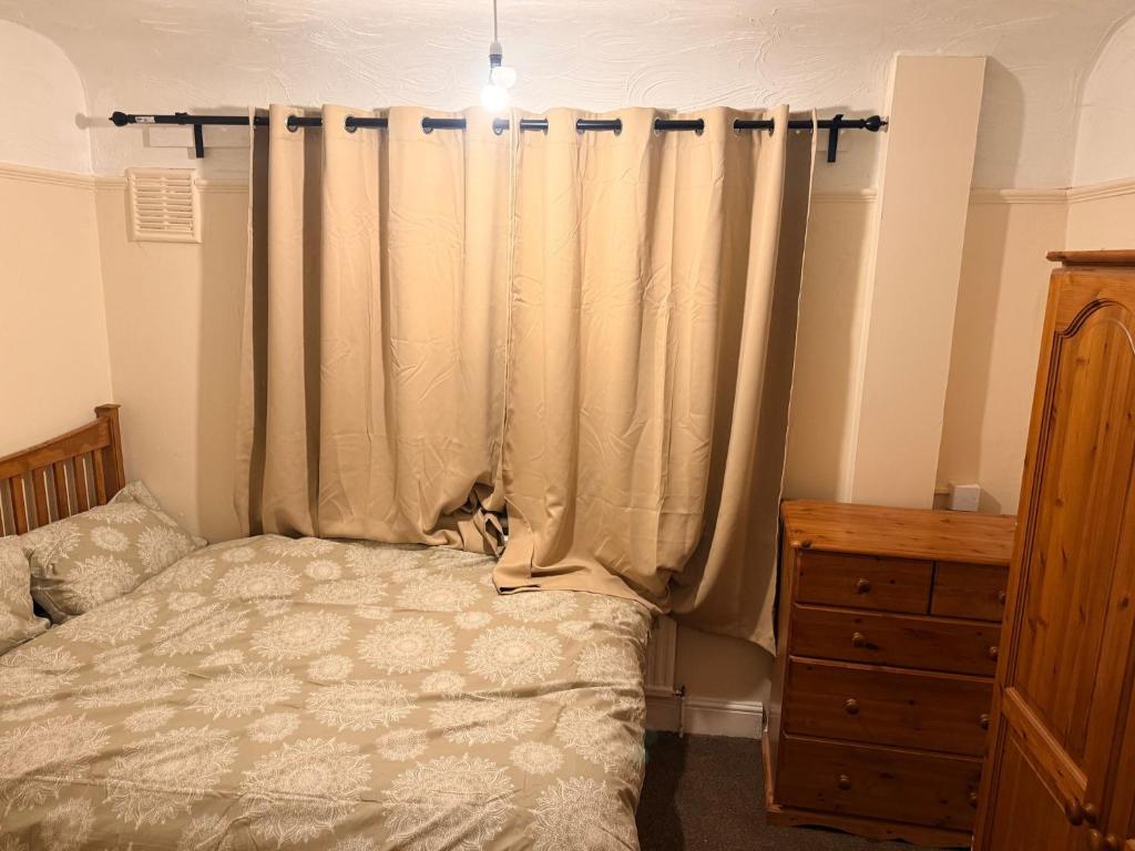 a bedroom with a bed and a curtain at Warn Cossy Luxe Room in Addington