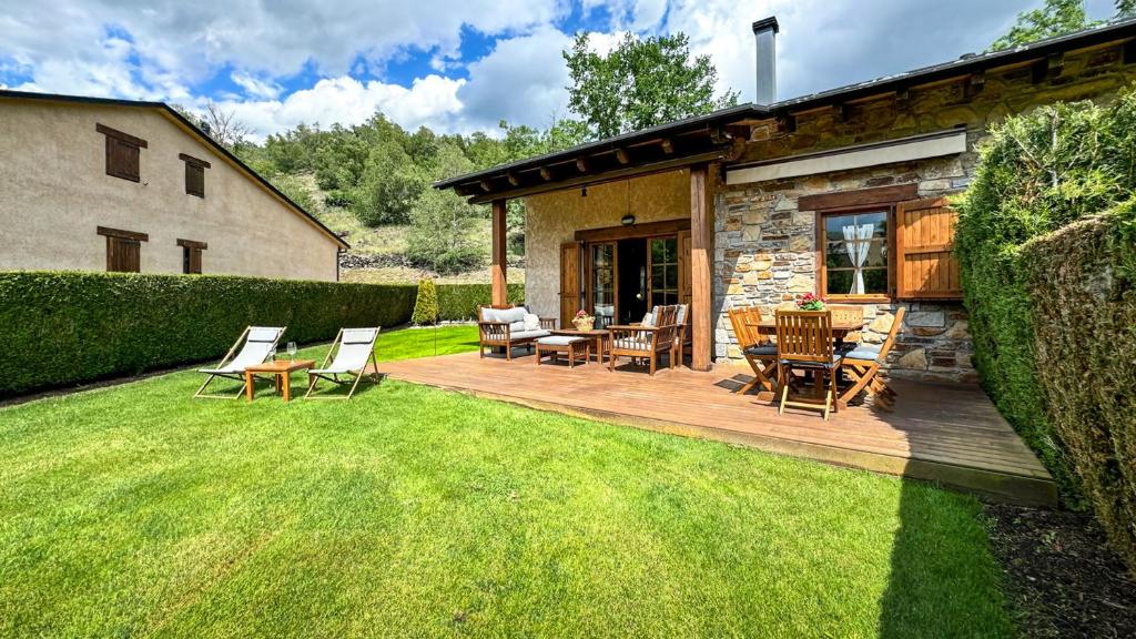 una terrazza in legno con sedie e un tavolo in un cortile di La Maison du Fleuve a Ur