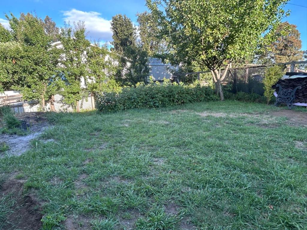a yard with green grass and a fence at Habitación Chilota in Castro