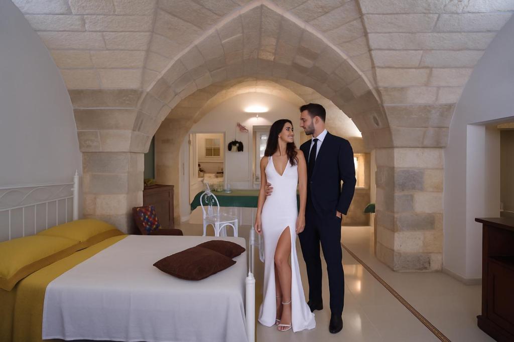 Ein Mann und eine Frau stehen neben einem Bett in der Unterkunft Mille908 in Muro Leccese