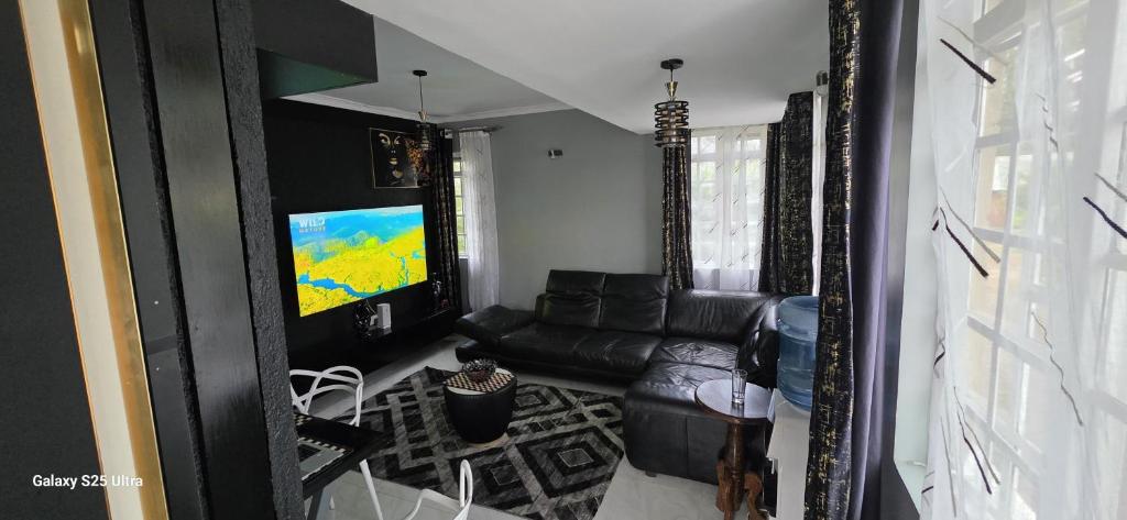 a living room with a couch and a flat screen tv at Armana Elite Homes in Paulo