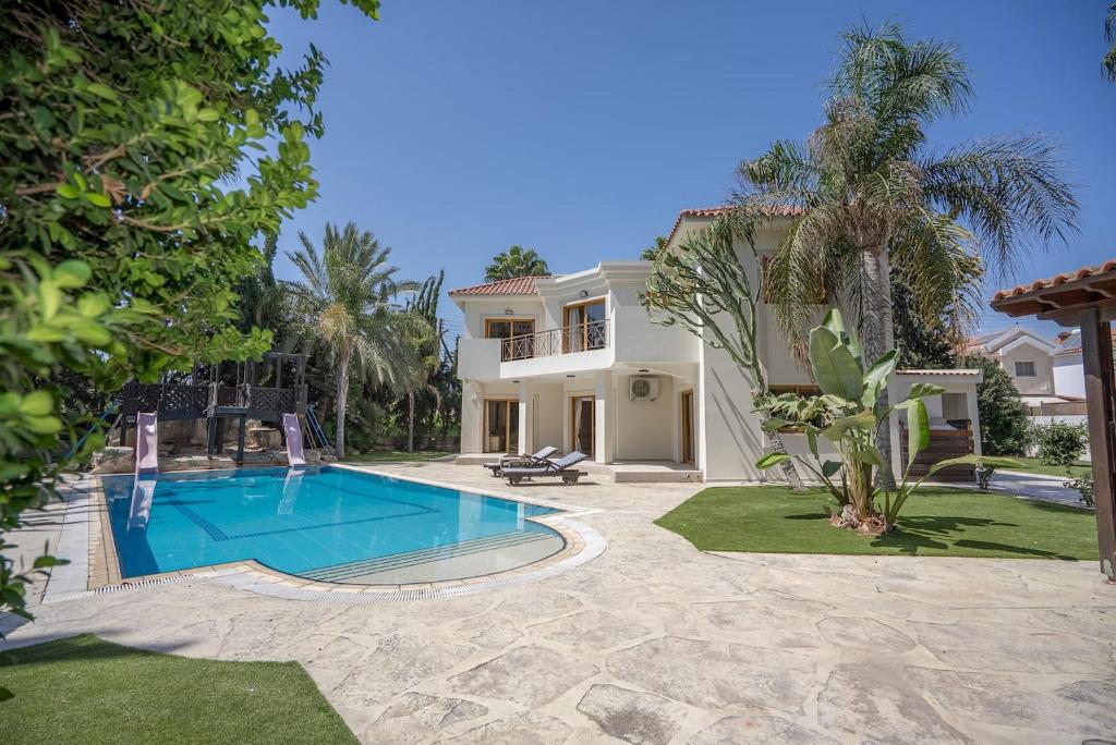 Blue Pearl Villa - 6 Bedroom في بيلا: منزل به حوض سباحة في الفناء