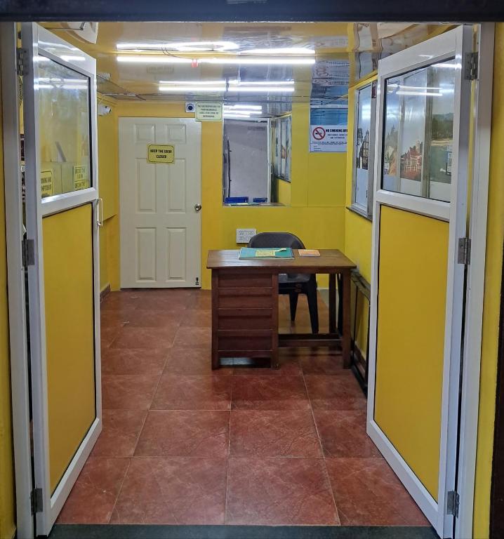 a hallway with a desk in a room with yellow walls at Backpackers Inn in Panaji