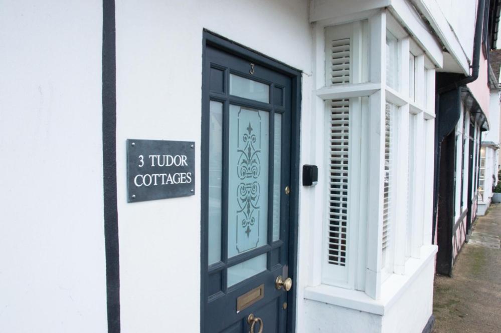 een zwarte deur aan de zijkant van een gebouw bij 3 Tudor Cottages in Long Melford