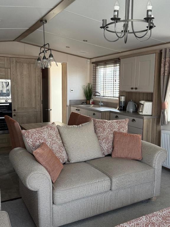 een woonkamer met een bank en een keuken bij Bishops Beach Stays in Walton-on-the-Naze