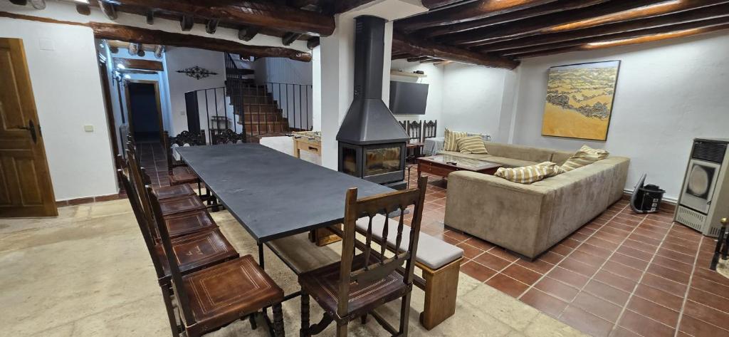 a living room with a table and a fireplace at Casa La Fuencisla in Castiltierra