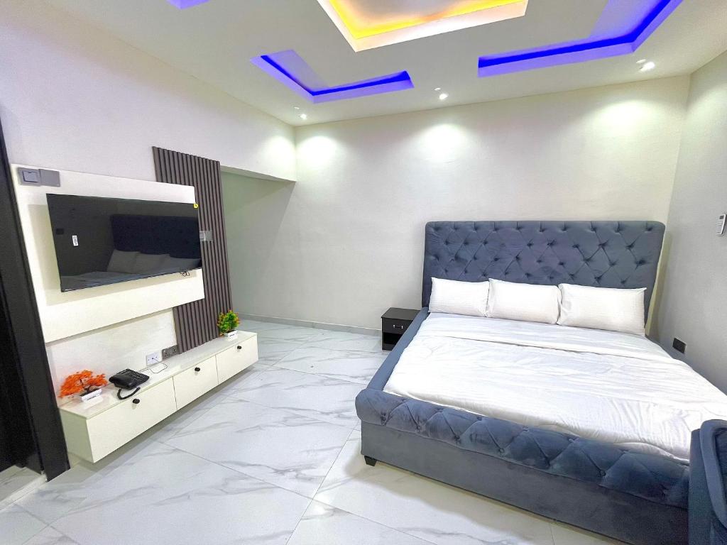 a bedroom with a bed and a flat screen tv at Fadaka Manor in Ibadan