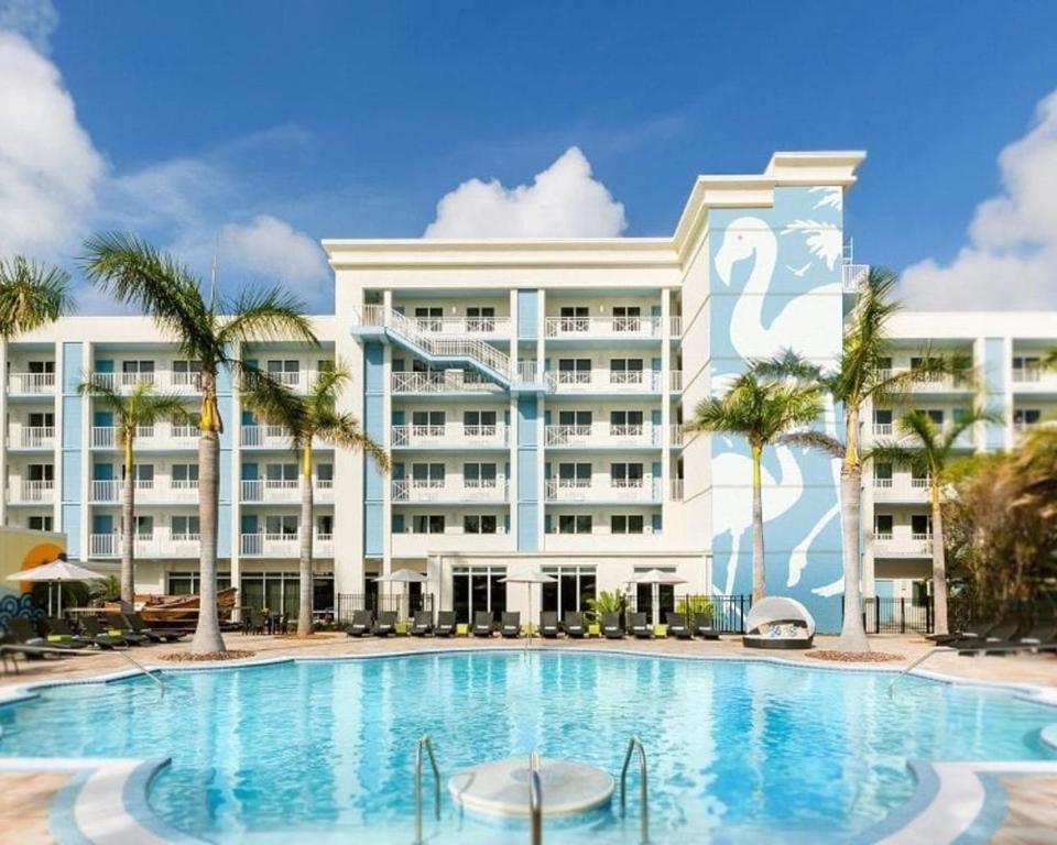 a large hotel with a swimming pool and palm trees at Blue Flamingo Resort Key West in Key West
