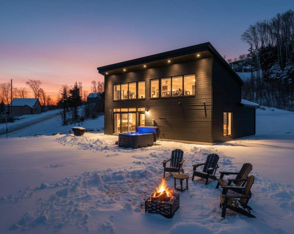 a cabin in the snow with a fire in front of it at Modern Comfort - Spa - Mountain - Chalet KNOX in Saint Come