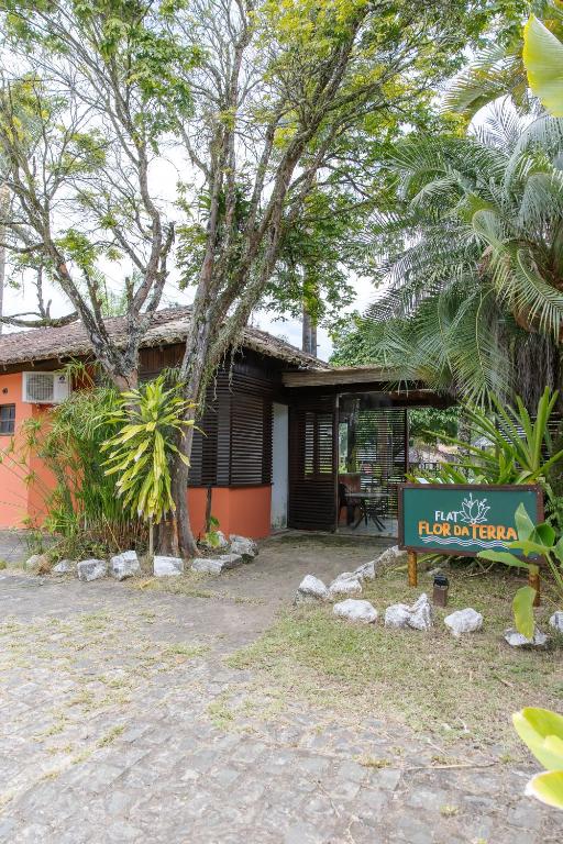 a house with a sign in front of it at Flat Flor da Terra in Itacaré