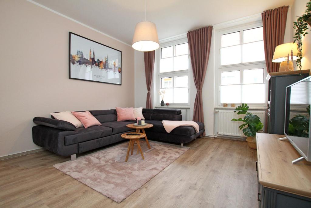 a living room with a black couch and a table at Gästewohnung "Harzliebe" in Halberstadt