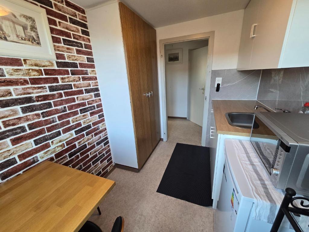 a kitchen with a brick wall at Central studio apartment stgallen gratis Parkplatz in St. Gallen