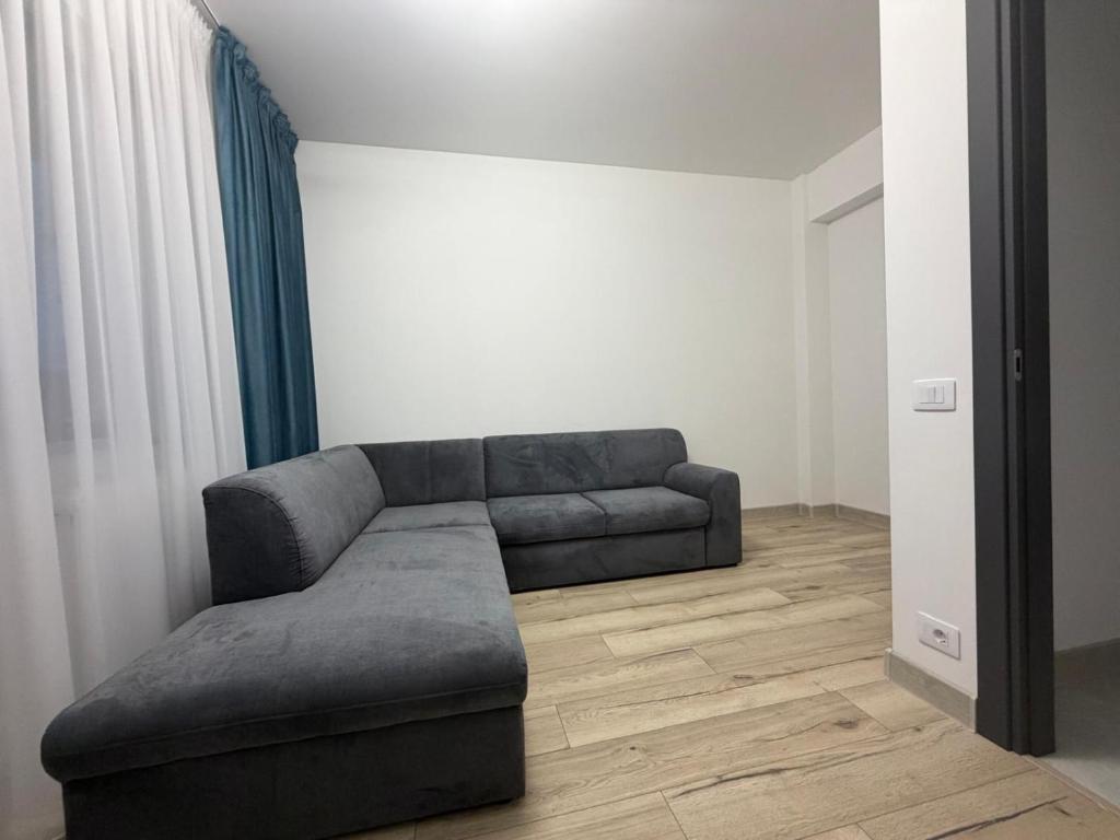 een woonkamer met een bank in een kamer bij Altheda Living Stejari 4B in Suceava
