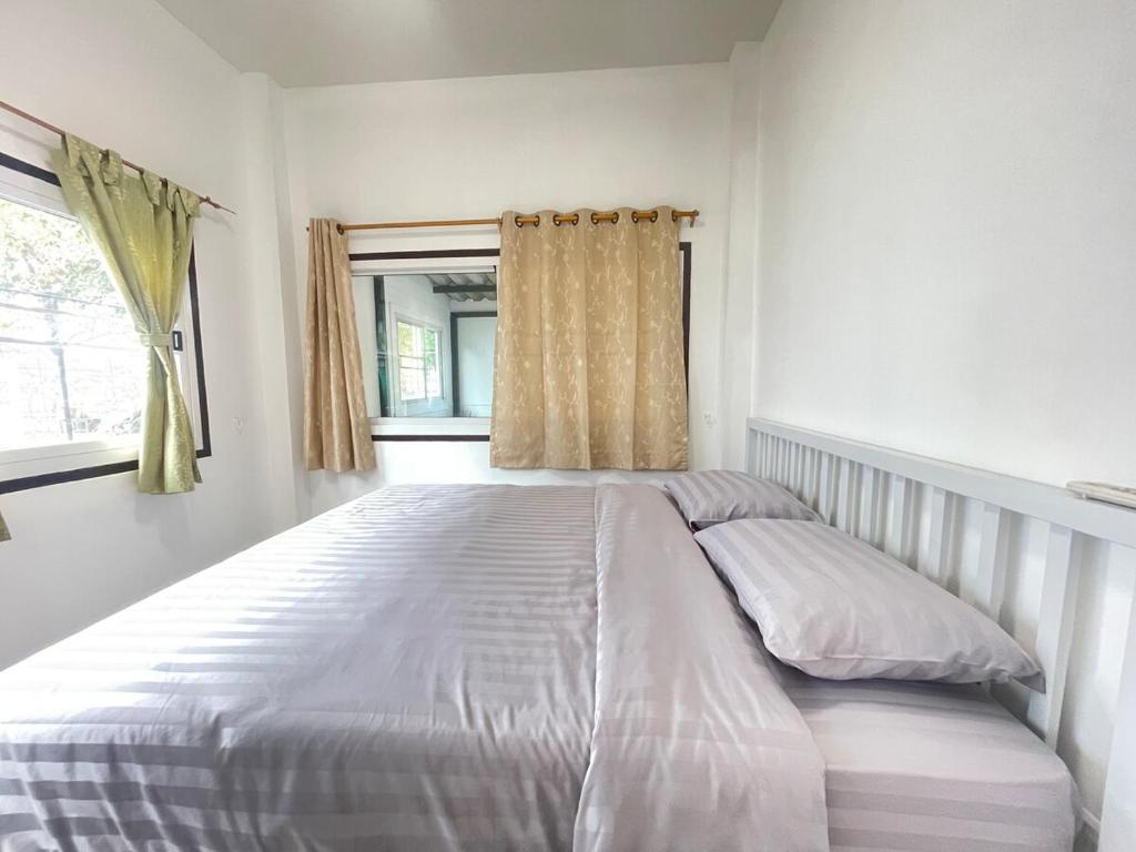 a large white bed in a bedroom with a window at Haiya Holiday House 2 in Ban Hua Phrong