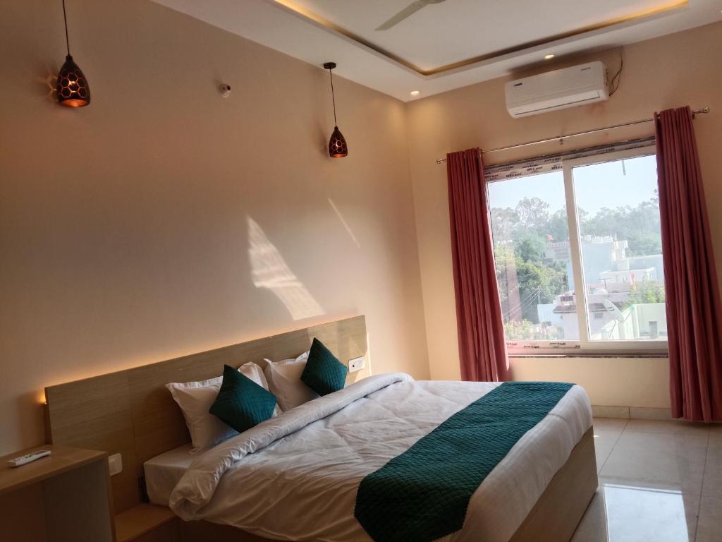 ハルドワニにあるAamayaのベッドと大きな窓のある寝室