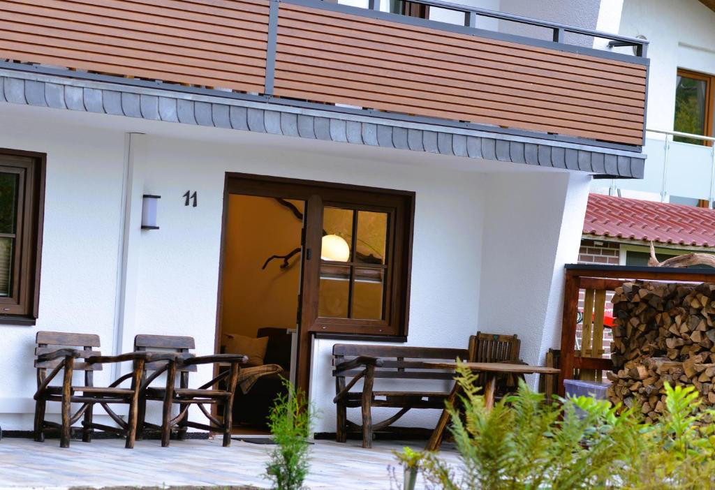 ein Gebäude mit zwei Bänken und einem Tisch und Stühlen in der Unterkunft Ferienwohnung Brama in Reinhardshagen