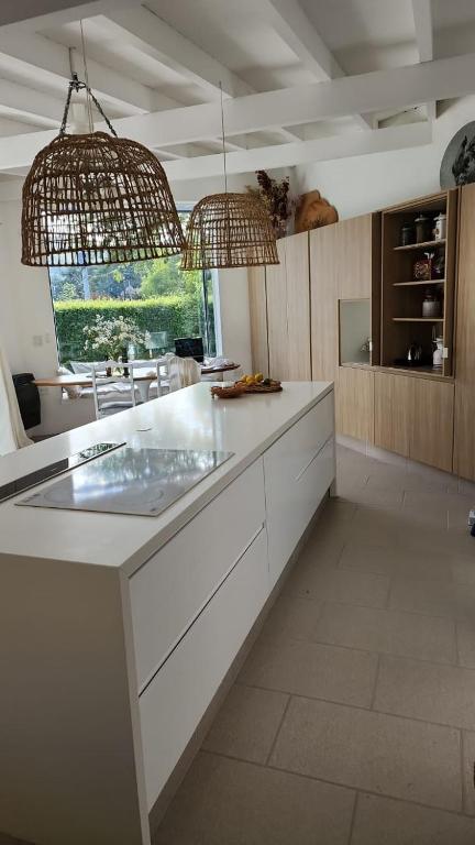 a kitchen with two chandeliers and a white counter top at Casa del Cielo in La Cumbre