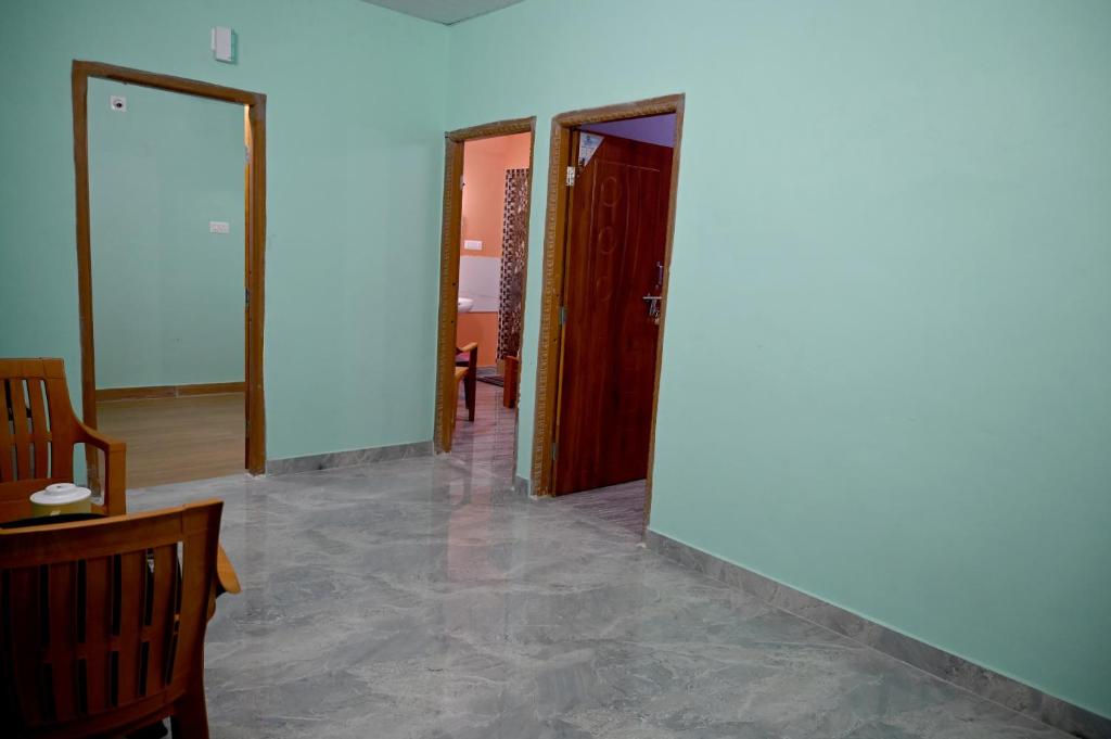 een hal met twee deuren en een tafel en stoelen bij Happy Homestay in Māvalli