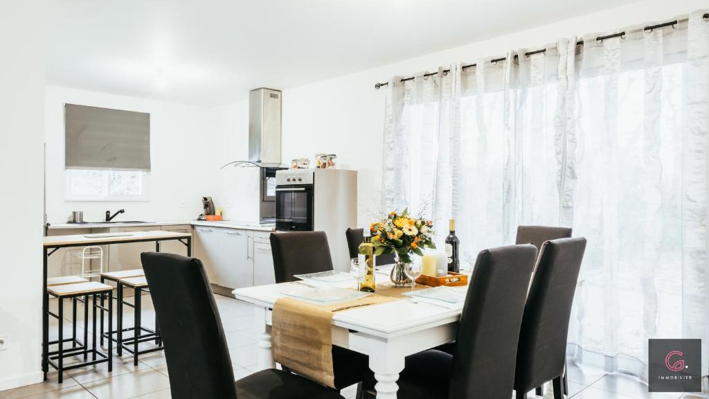 a kitchen and dining room with a table and chairs at Sanguinet - Élégante maison pour 6 personnes PMR in Sanguinet