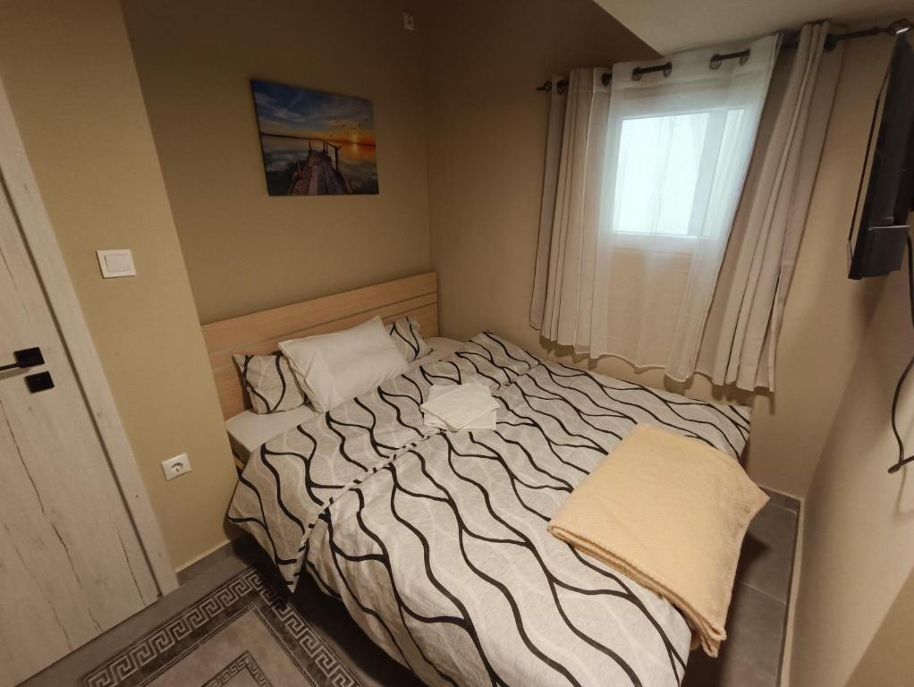a bed in a small room with a window at knezevic resorts 14 in Mesochórion