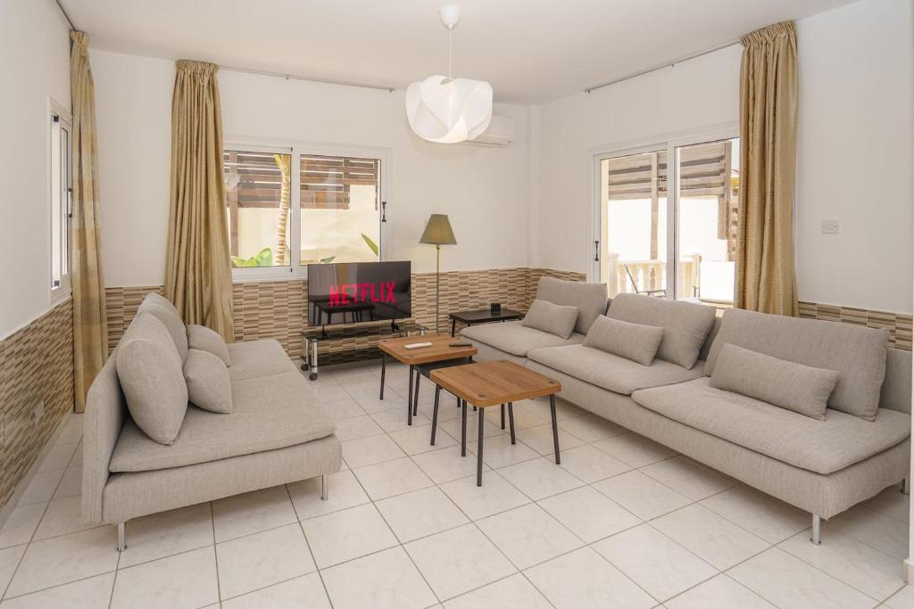 Seaside Villa Luci w jacuzzi في باراليمني: غرفة معيشة مع أريكتين وتلفزيون