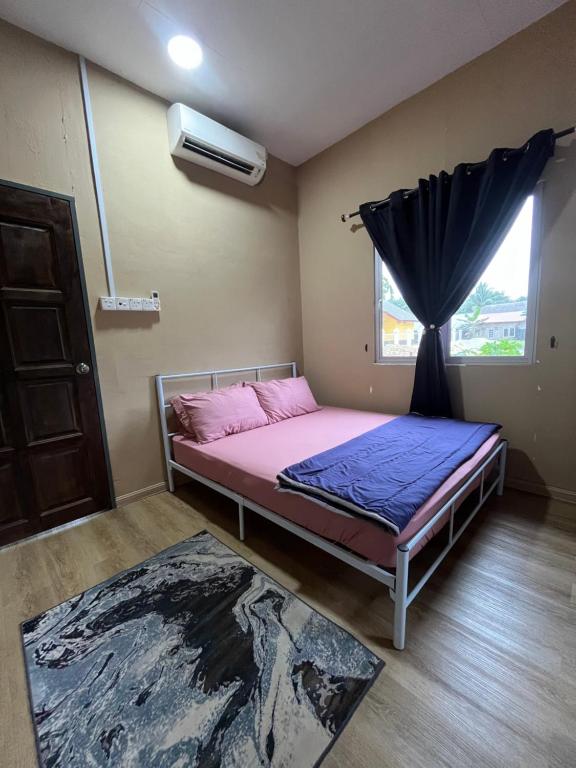 a bed in a room with a window and a bed sidx sidx sidx at FMAZ Cottage in Kampong Gong
