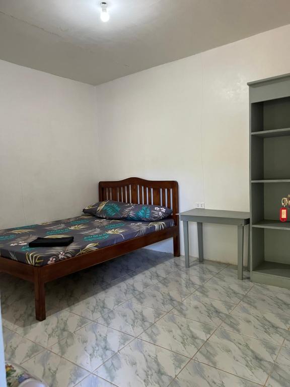 - une chambre avec un lit en bois et une table dans l'établissement Bai Quaba, à El Nido