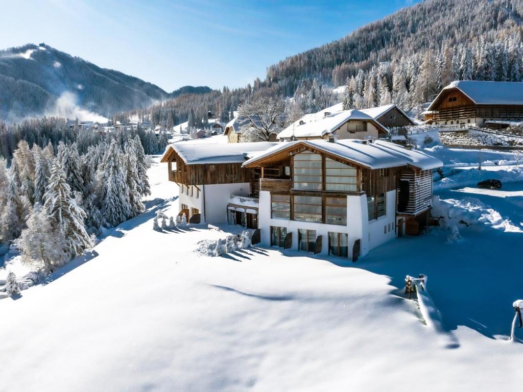 un lodge en la nieve con árboles nevados en Miraval NaturHotel, en Badia
