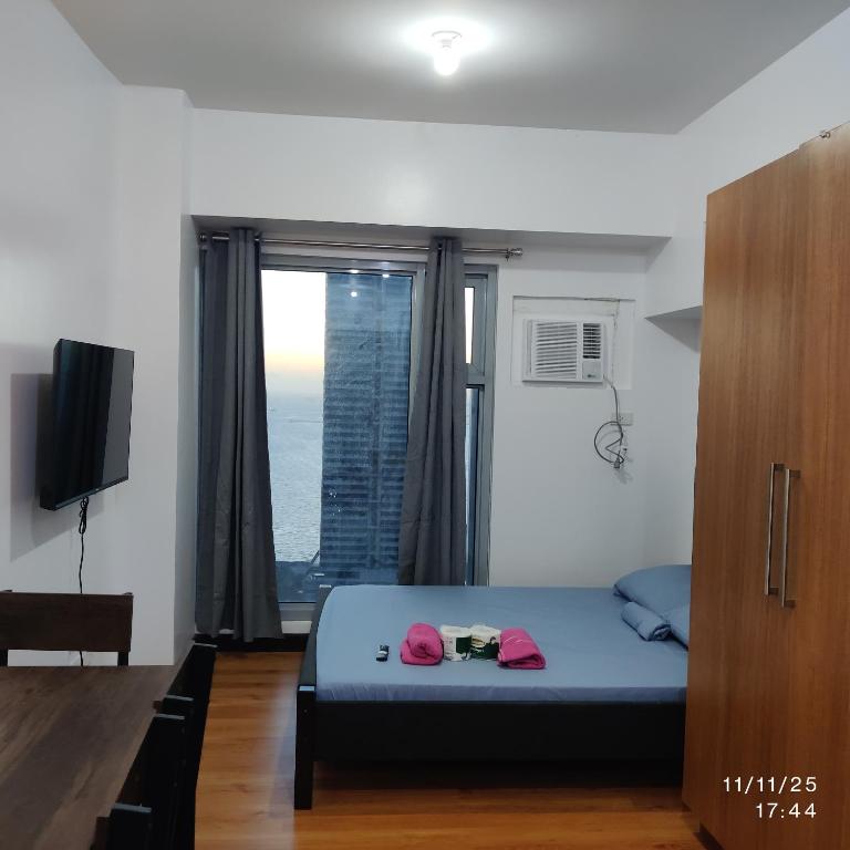 a bedroom with a bed and a large window at 8Adriatico Condo near US Embassy in Manila