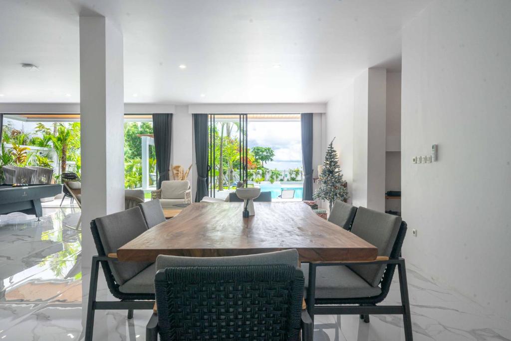 a dining room with a wooden table and chairs at Gandum Villa Complex - Luxury Boutique Stay Uluwatu in Uluwatu
