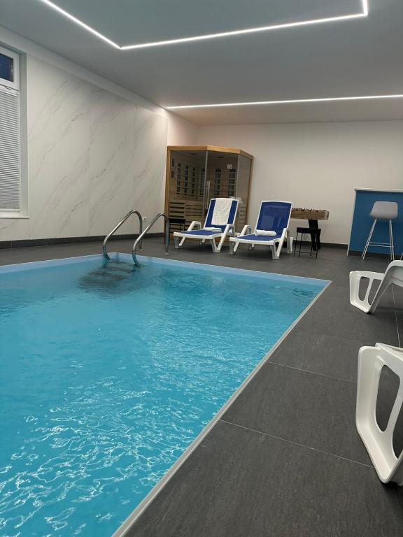 a swimming pool with blue chairs in a room at Vacation Home Mo Star with Swimming pool and Sauna in Mostar