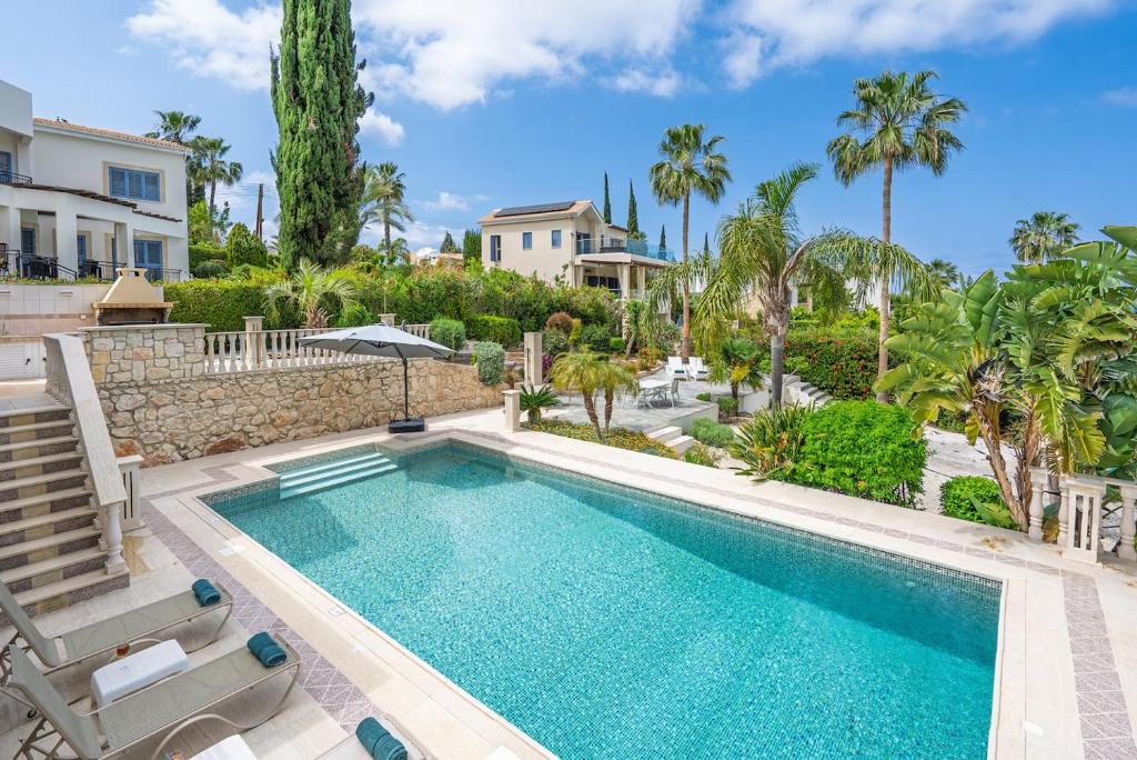 Seaview Villa Selenia pool & jacuzzi in Neo Chorio في نيو تشوريو: حمام سباحة مع كرسيين ومنزل