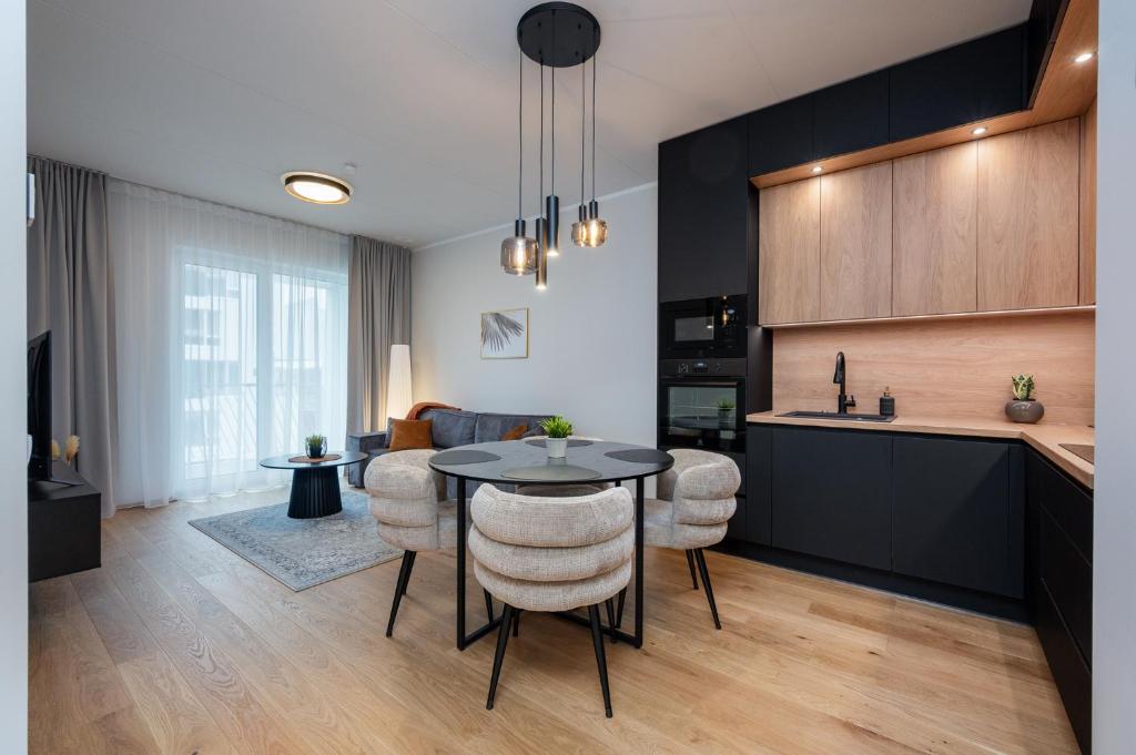 a kitchen and living room with a table and chairs at Cosy River Suite in Tartu