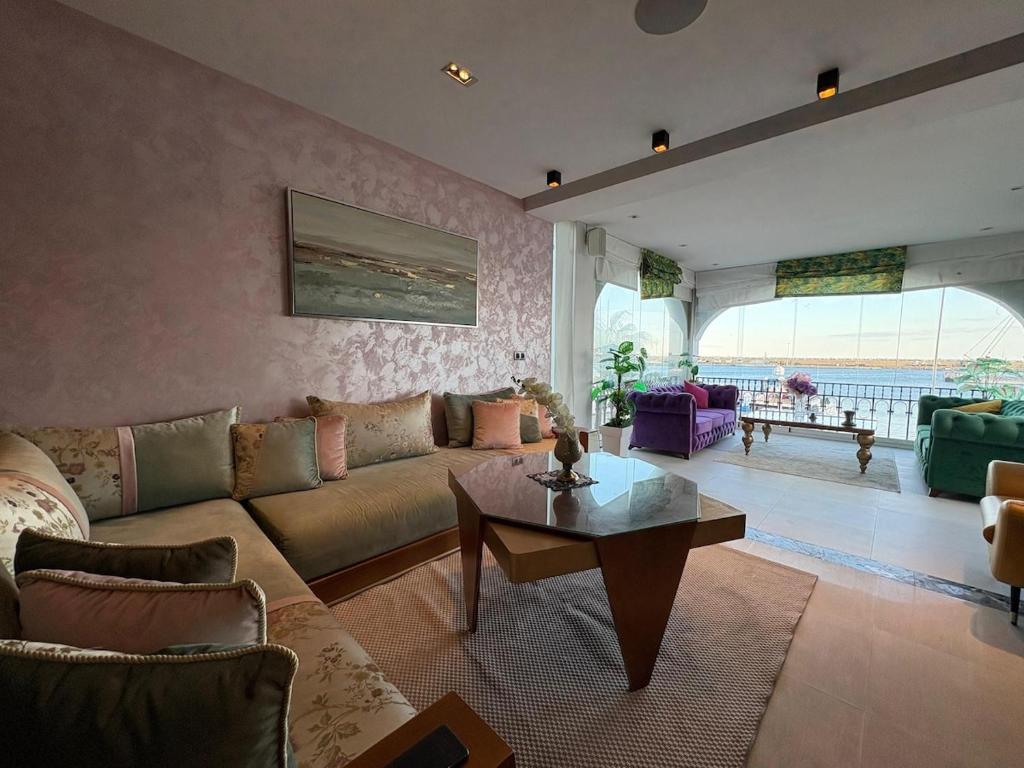 una sala de estar con un sofá y una mesa en Marina Smir Port Luxury 2BR - Seaview - Beachfront, en Marina Smir