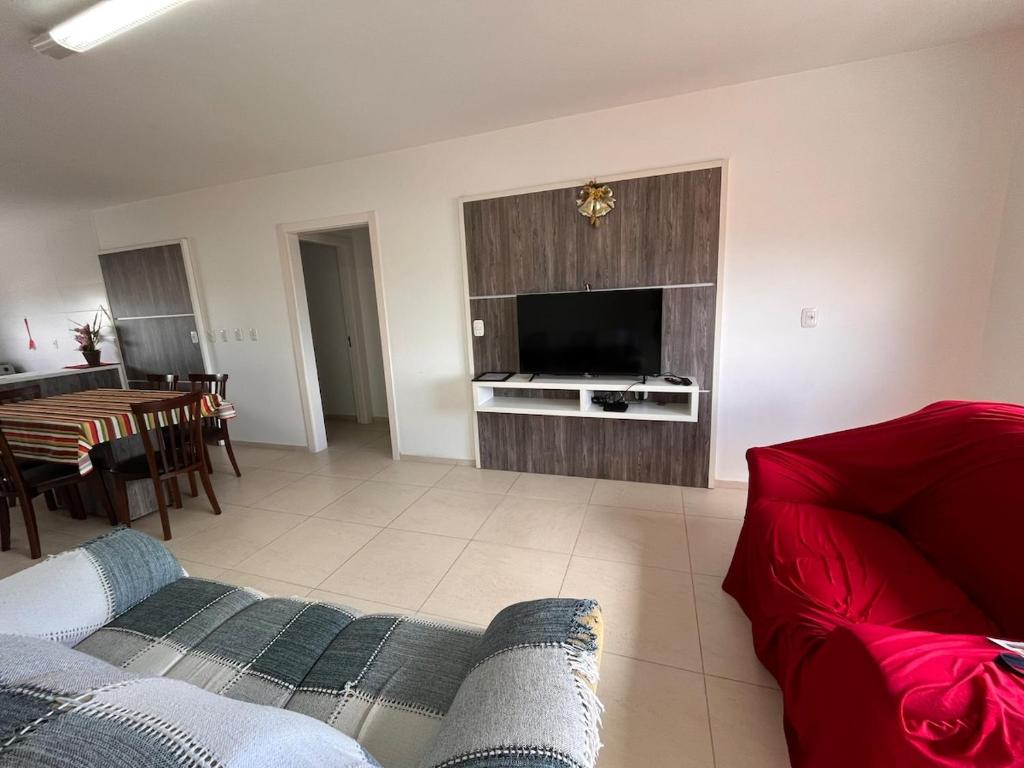 a living room with a couch and a television at Residencial Lazzari Apto 302 in Arroio do Sal