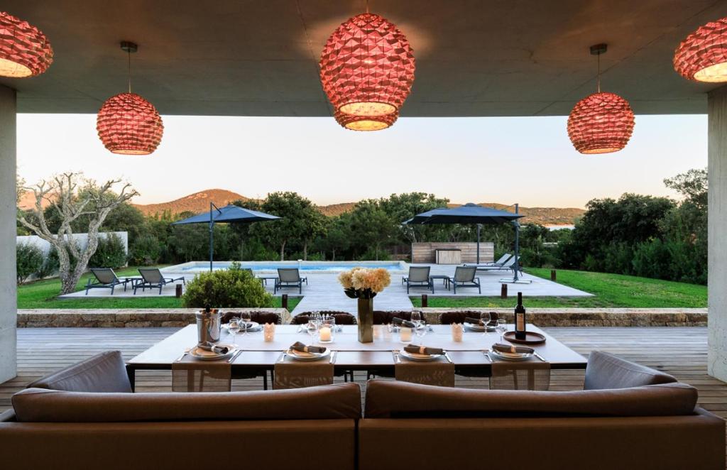 een patio met een tafel, stoelen en verlichting bij A Liccia in Pianottoli-Caldarello