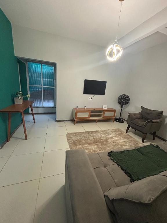 a living room with a couch and a flat screen tv at Casa Espaçosa - Caminhe até a Orla de Atalaia 650m in Aracaju