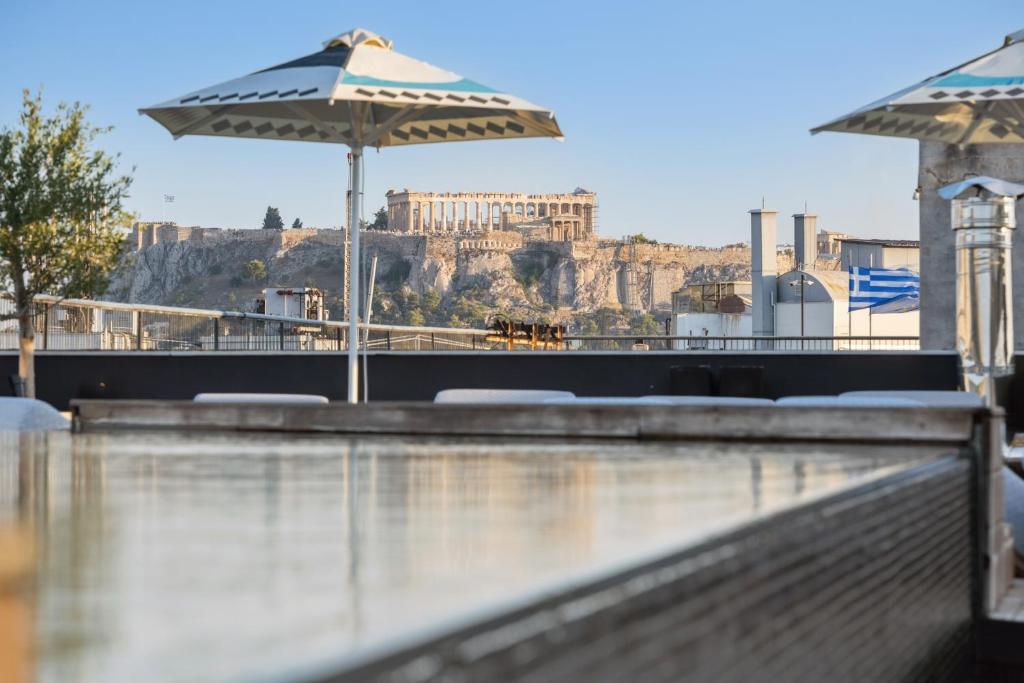 Skylark, Aluma Hotels & Resorts في أثينا: مسبح مزود بمظلة وإطلالة على الأكروبوليس