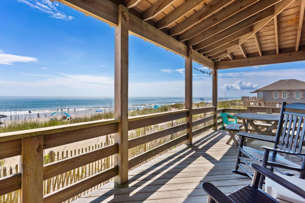 a porch with a table and chairs and the beach at 4020 - Gardners Hut in Kitty Hawk Beach